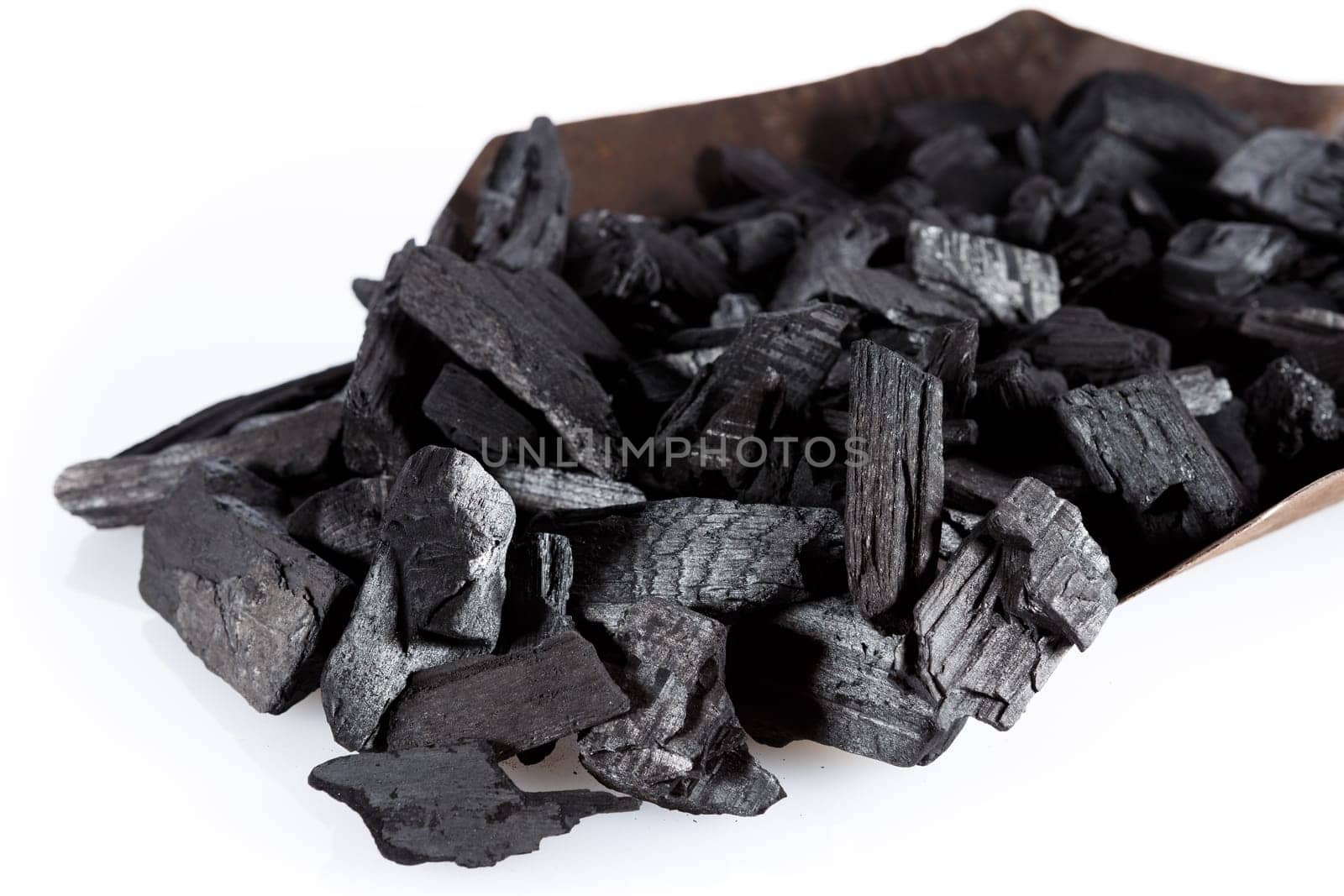 Pile of charcoal and shovel isolated on white