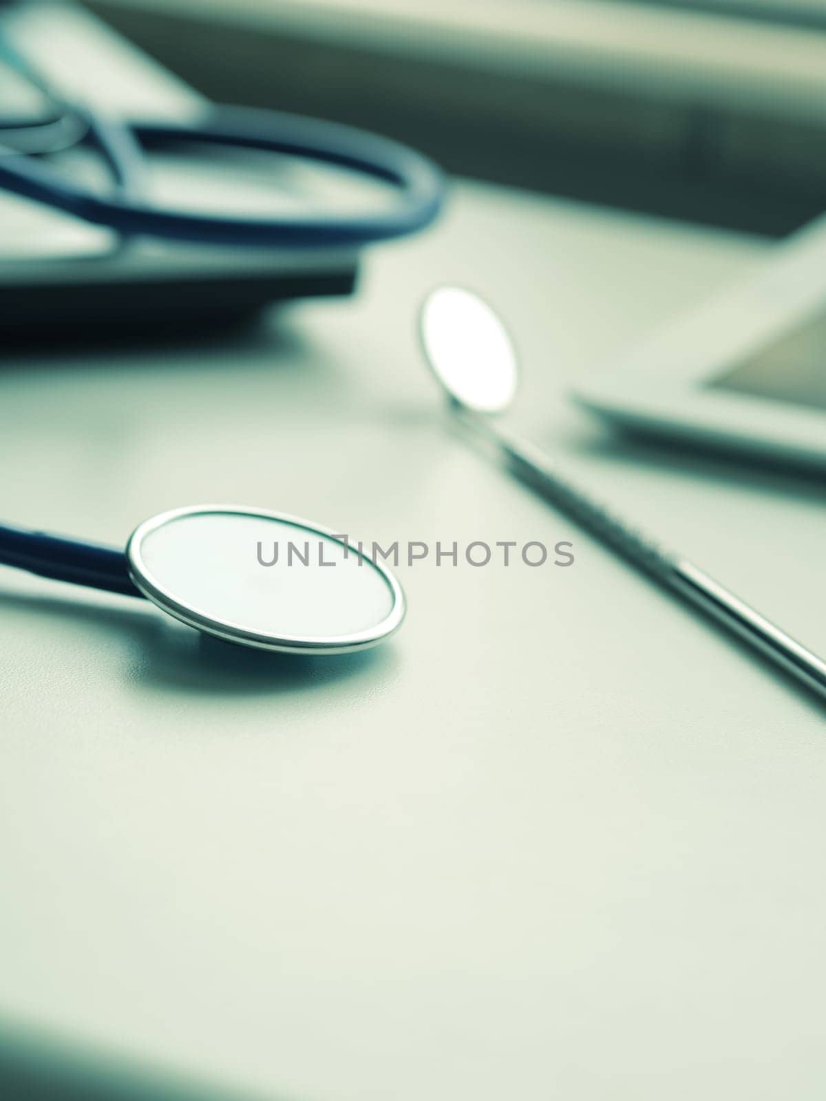 Medical utensils with laptop and tablet computer on a doctor's desk, close up shot with selective focus
