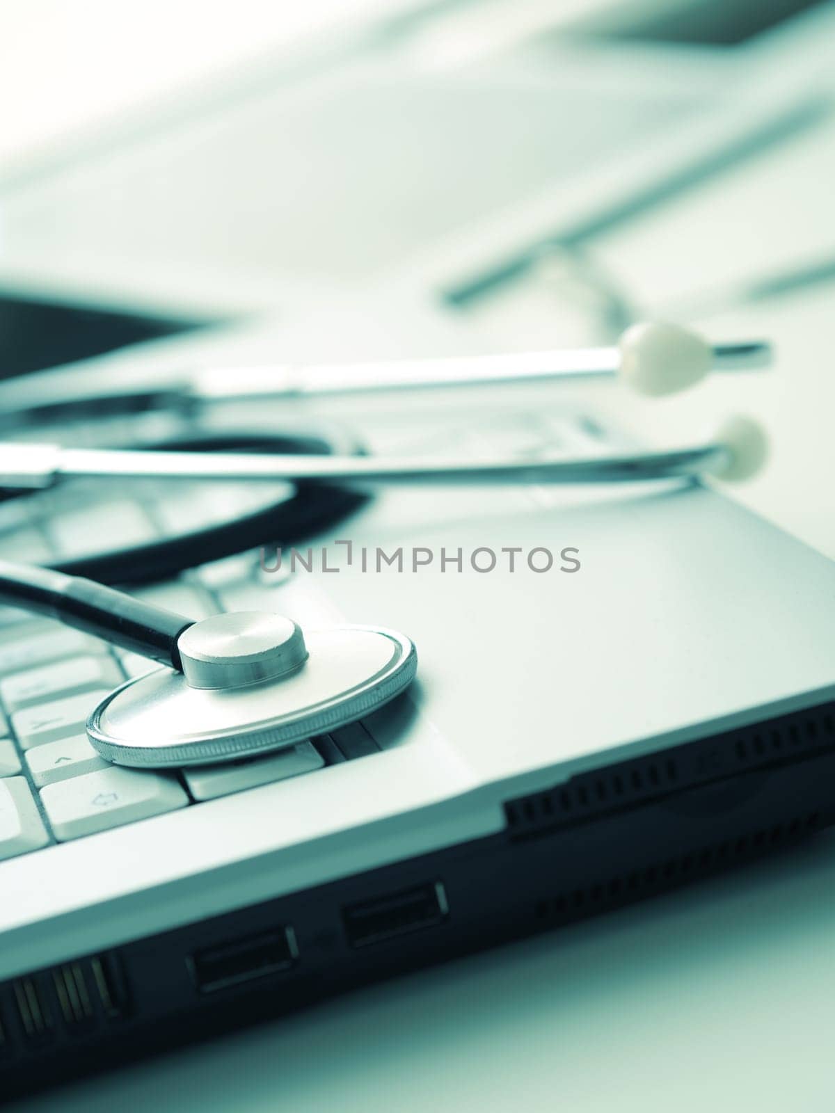 Medical utensils with laptop and tablet computer on a doctor's desk, close up shot with selective focus