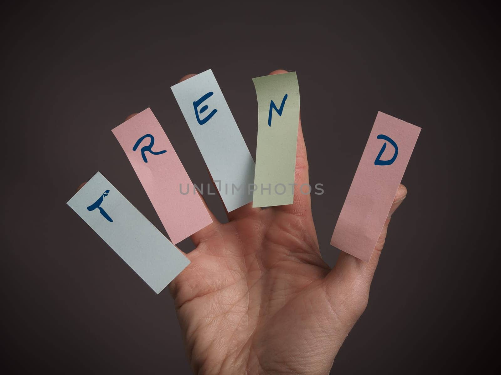 Male hand with five sticky notes and the word trend on it
