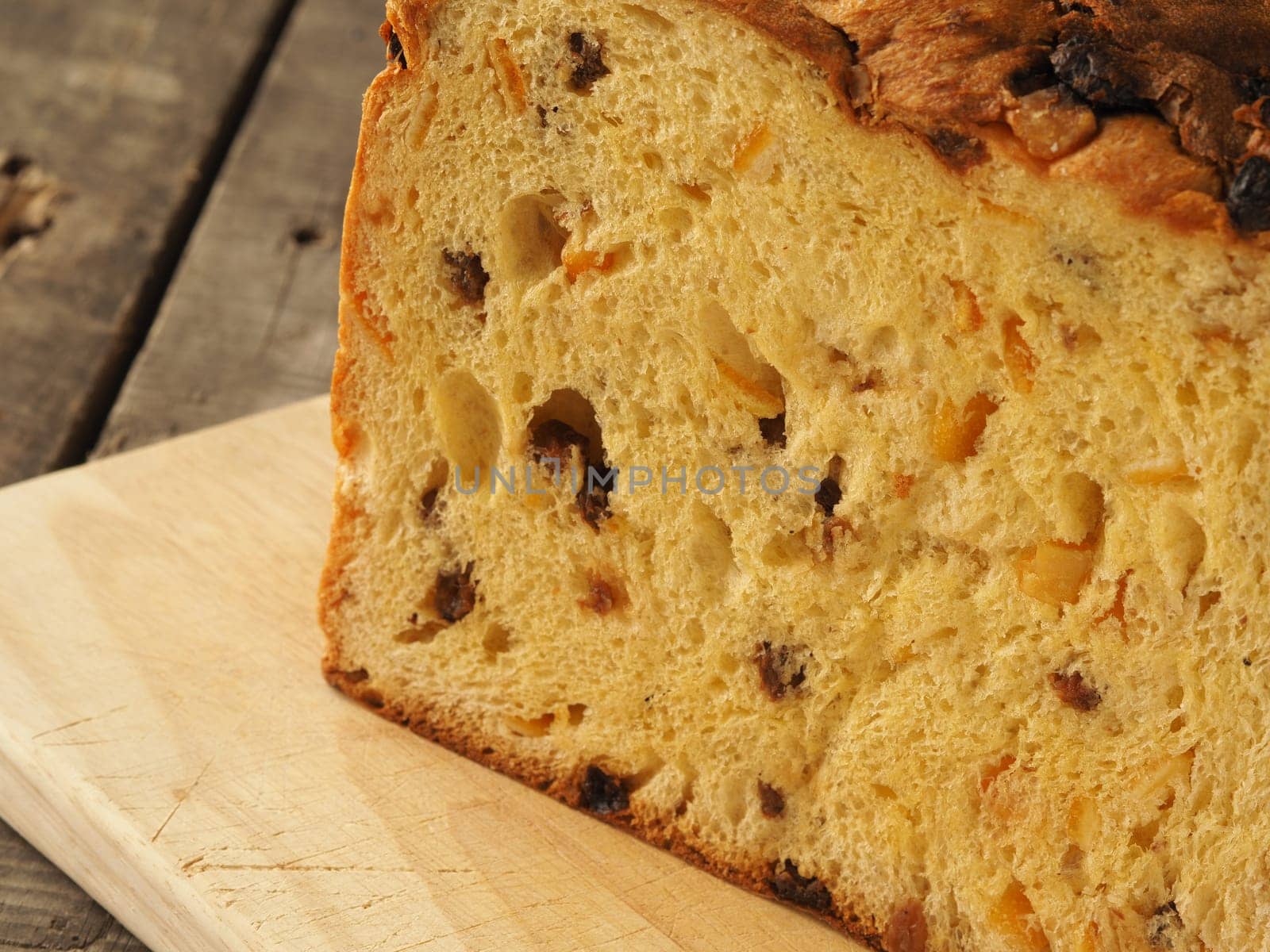 Typical Panettone on a wooden board in a rustic kitchen, close up shot