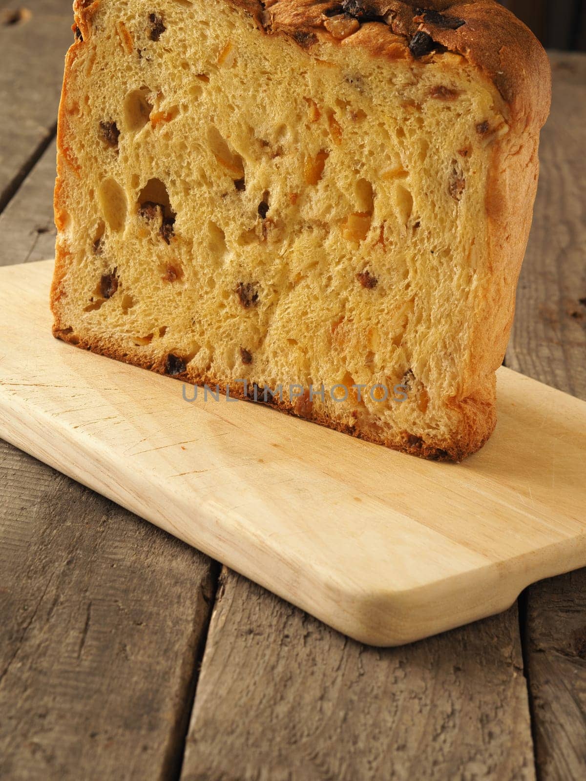 Original Panettone on a wooden board, close up shot in a rustic kitchen