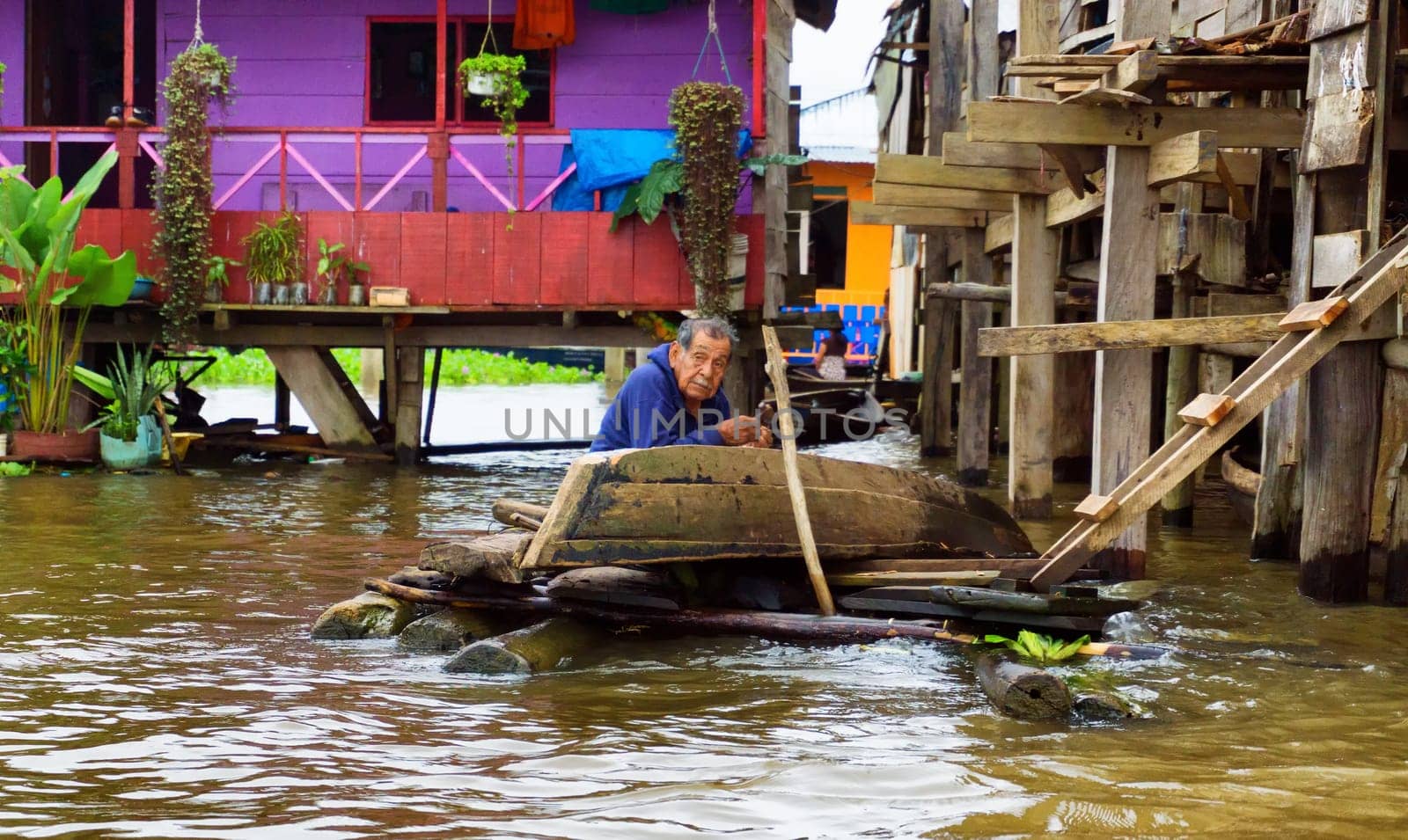 IQUITOS, PERU - MARCH 17: Elderly man fixes a canoe in Iquitos, Peru on March 17, 2015