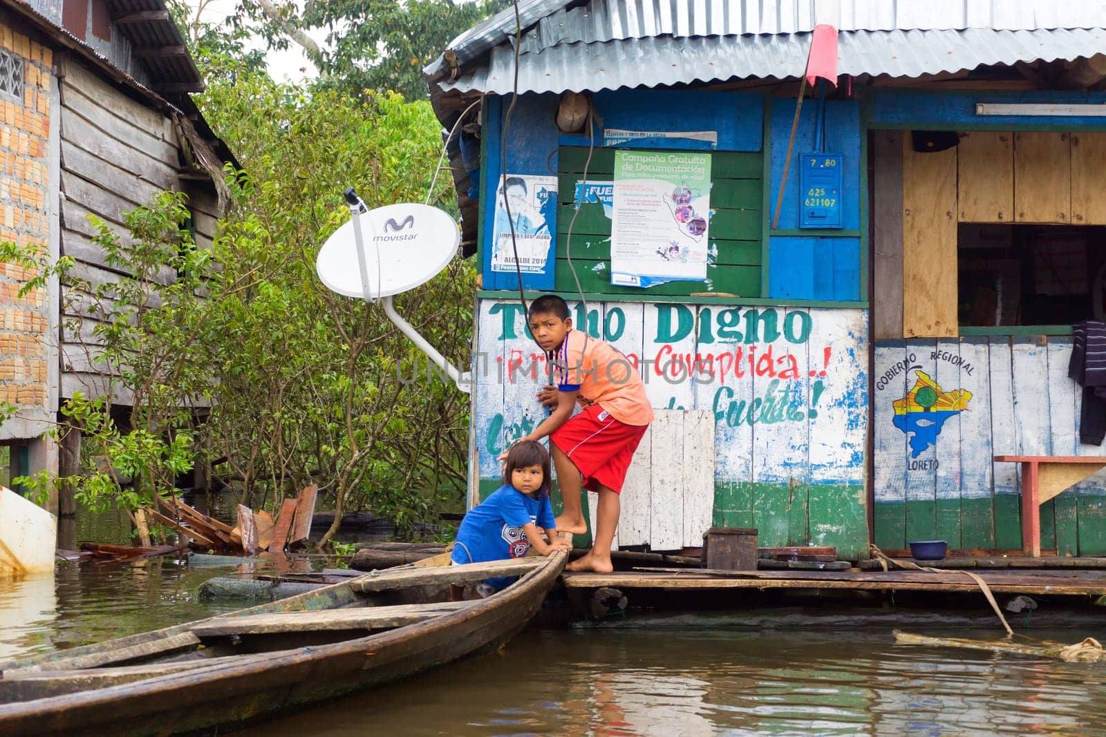 IQUITOS, PERU - MARCH 17: Children with a canoe on the river in Iquitos, Peru on March 17, 2015