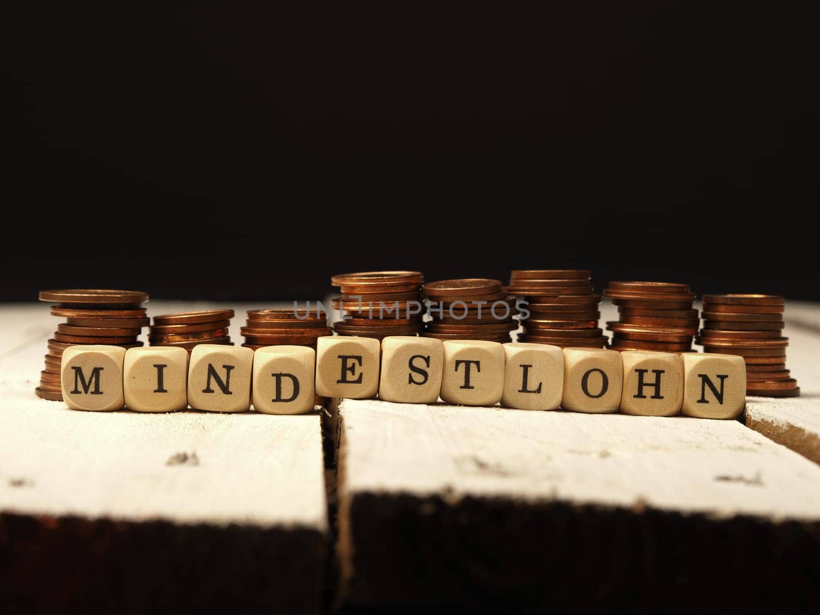Minimum wage concept with wooden cubes and change as a pile of money