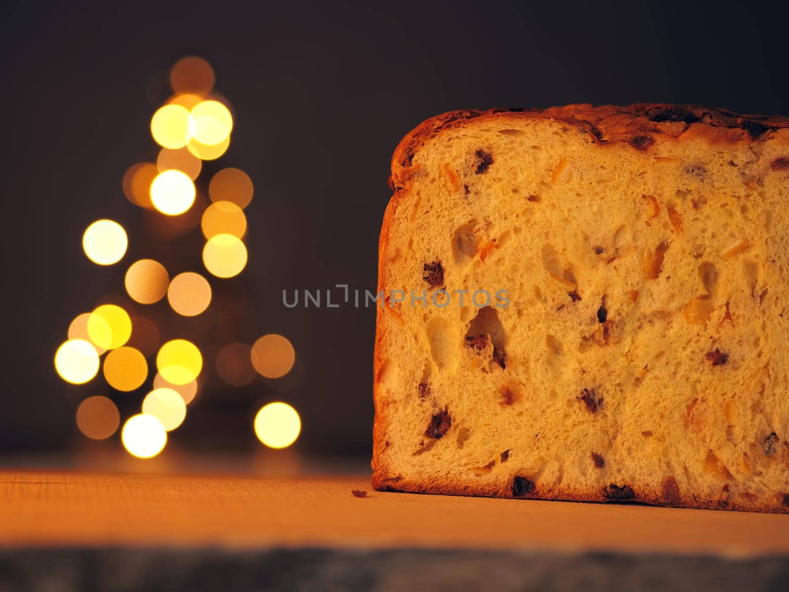 Half of a Panettone with a Christmas tree in background