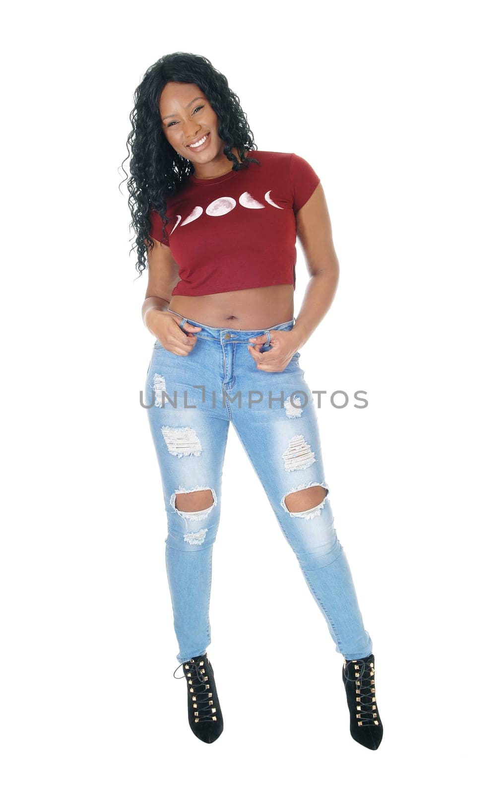 A beautiful African American woman standing in jeans from the front, .isolated for white background with her hands on her jeans..
