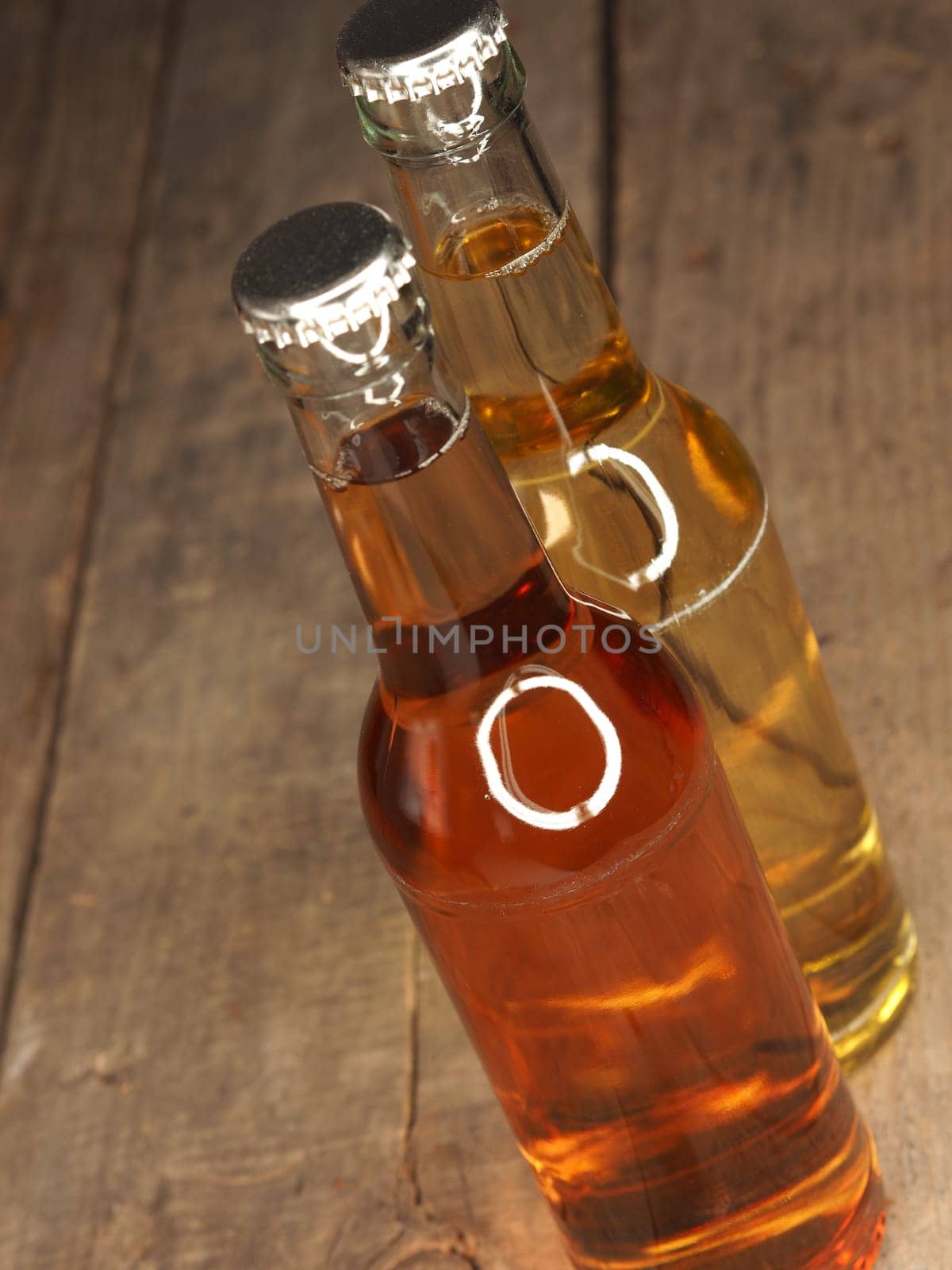 Two bottles of apple juice on an old rustic barn wood background