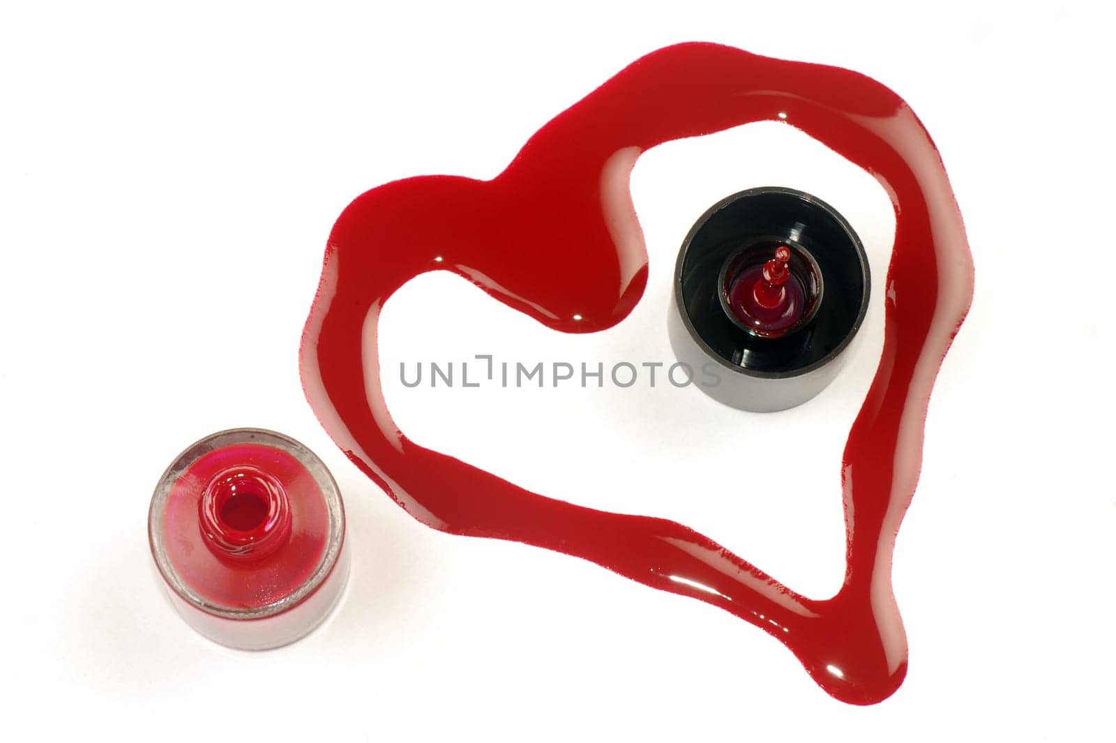 Heart shape from red nail polish on white background.