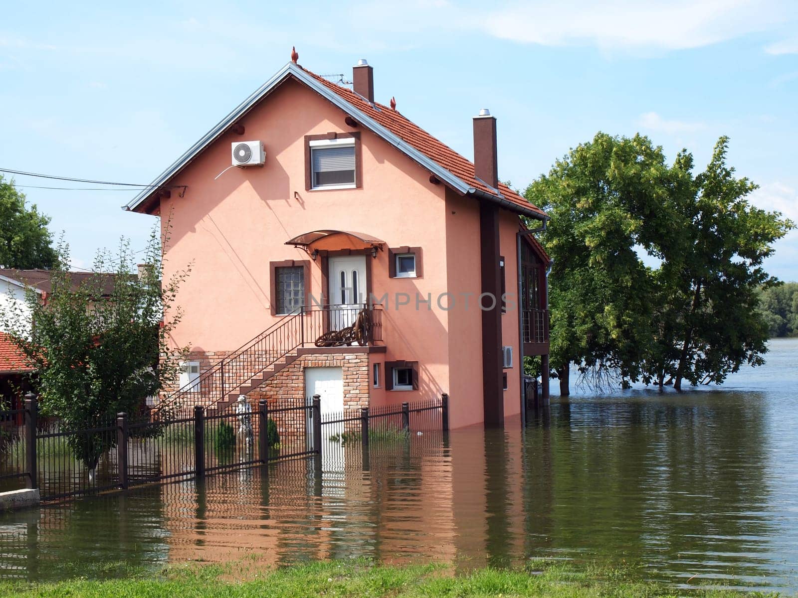 big flooded house with blue sky and white clouds in high water