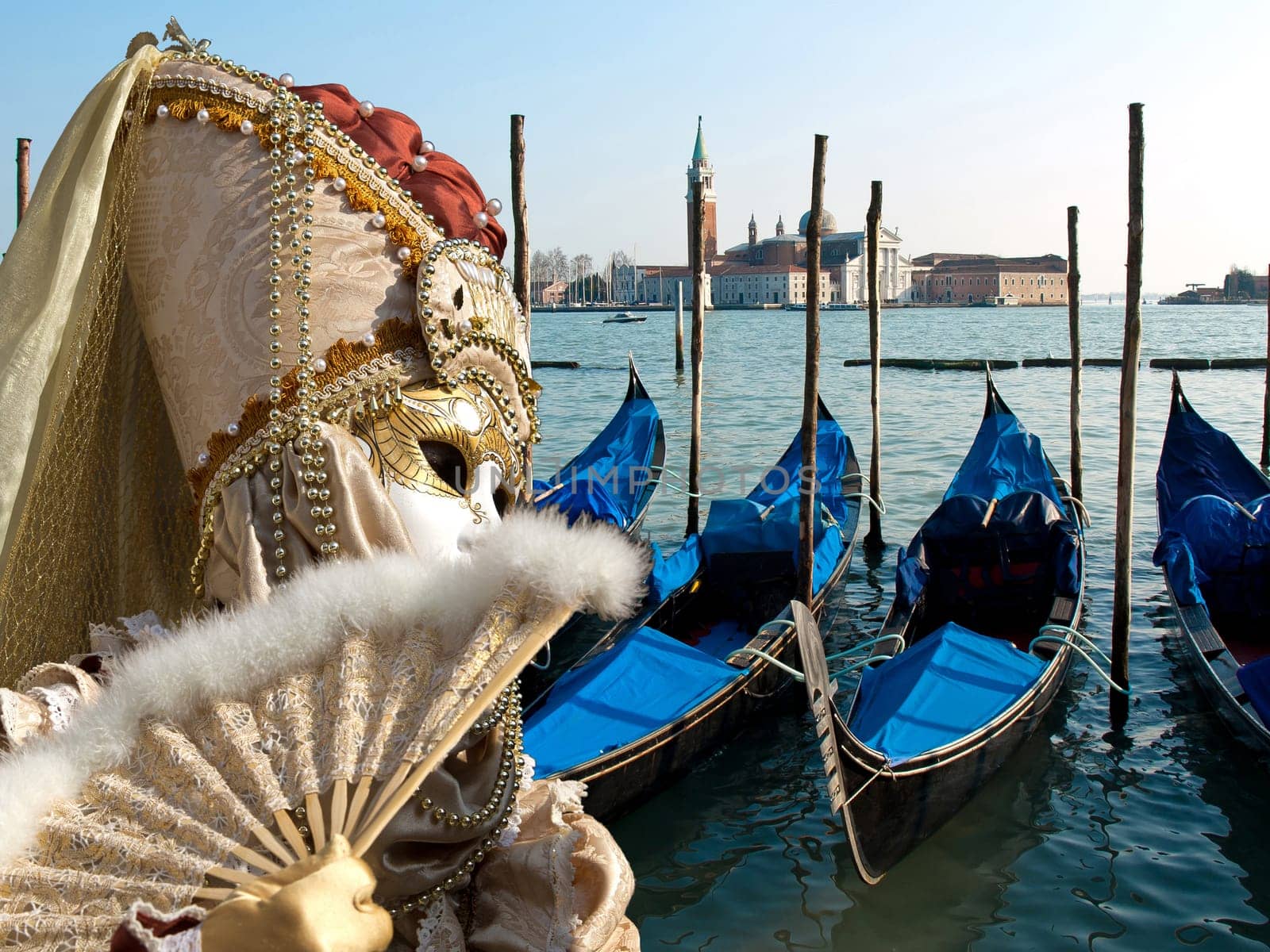 mask and gondola boats waiting for turists in the Venice