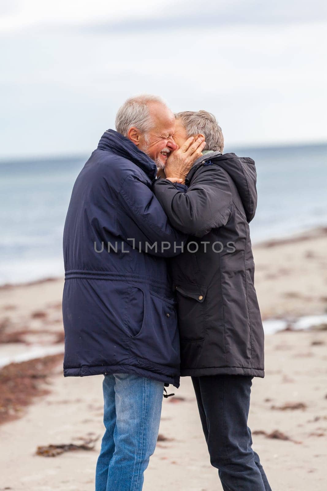 older adult happy couple walks on the beach in autumn lifestyle happiness