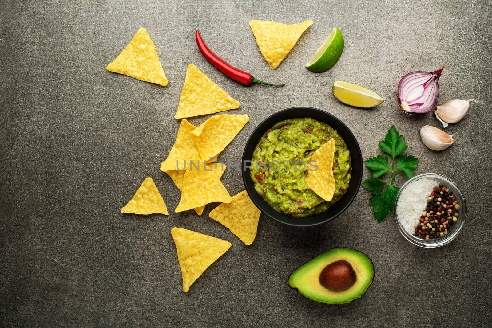 Guacamole sauce with fresh ingredients and corn nachos chips