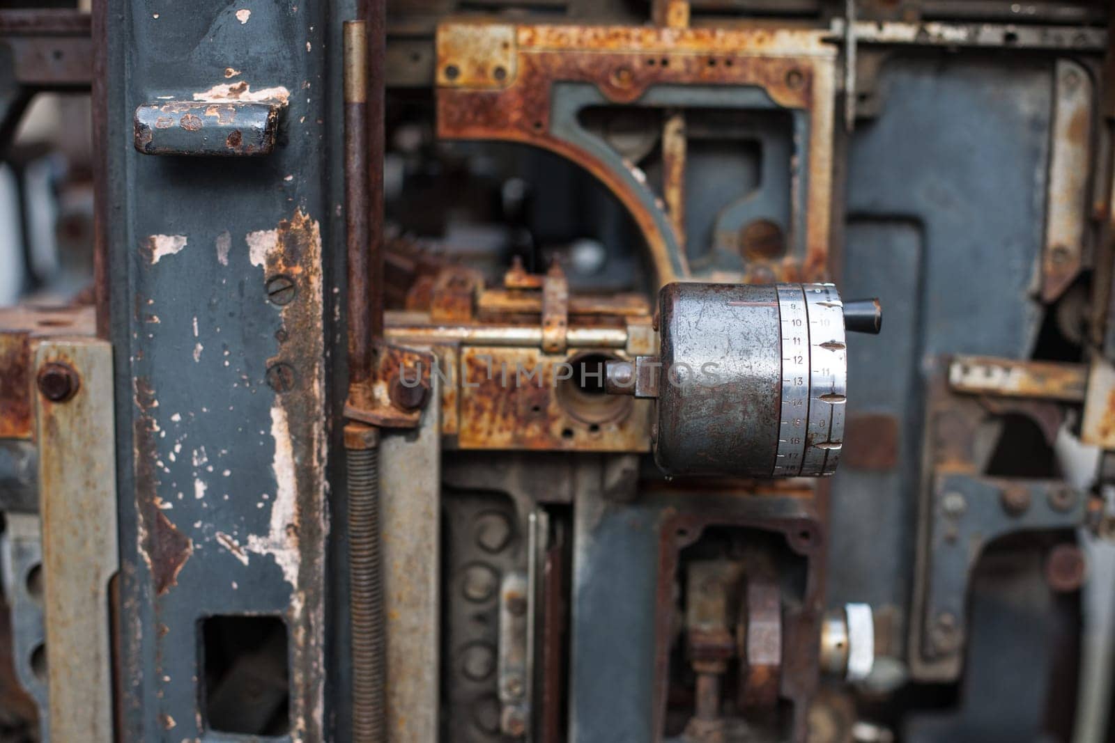 Old rusty printing machine complex mechanism of metal with close up details