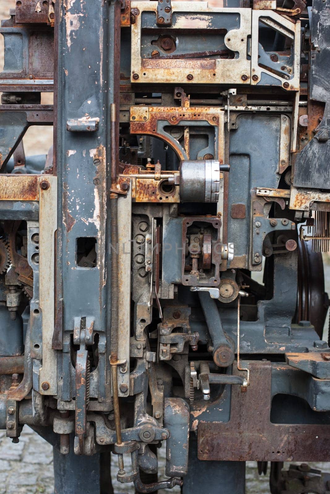 Old rusty printing machine complex mechanism of metal with close up details