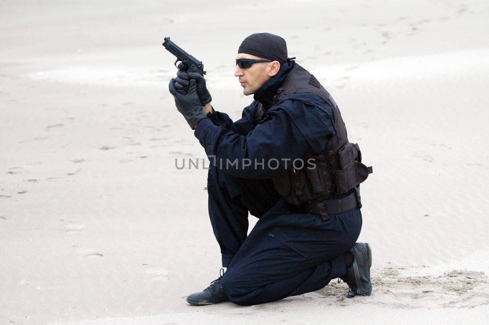 The security man with gun is in desert.
