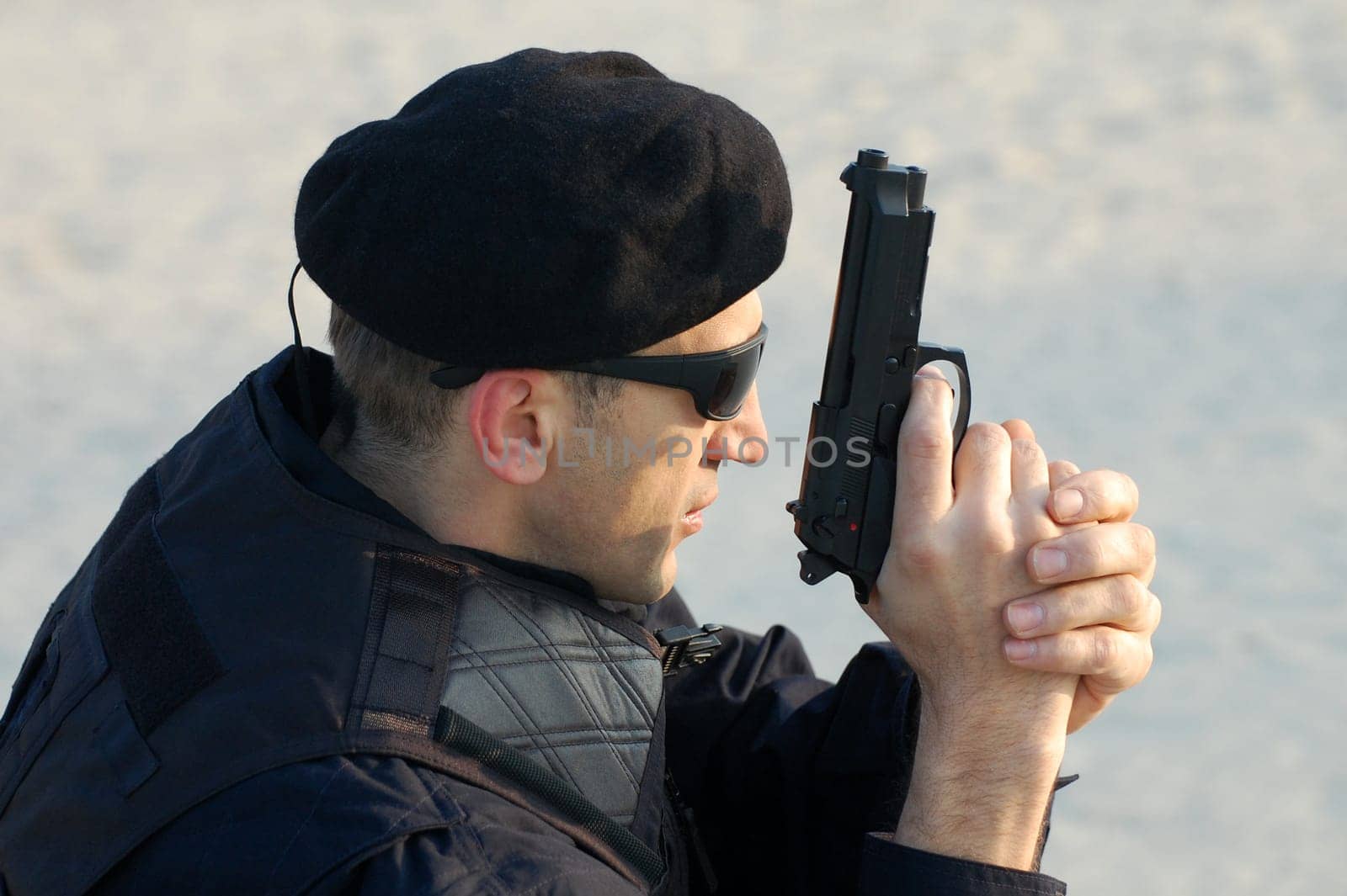 The security man is holding gun in his hands.