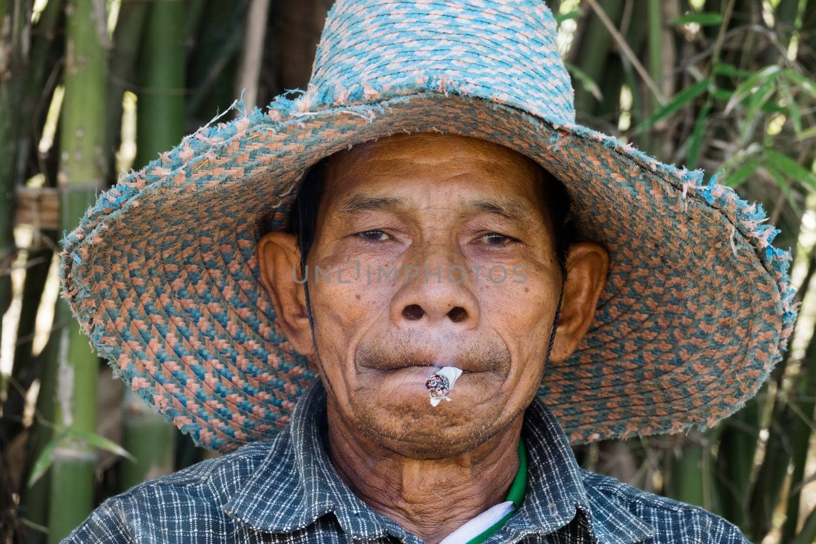 Old Asian man with cigarette Portrait of a smoking Thai man