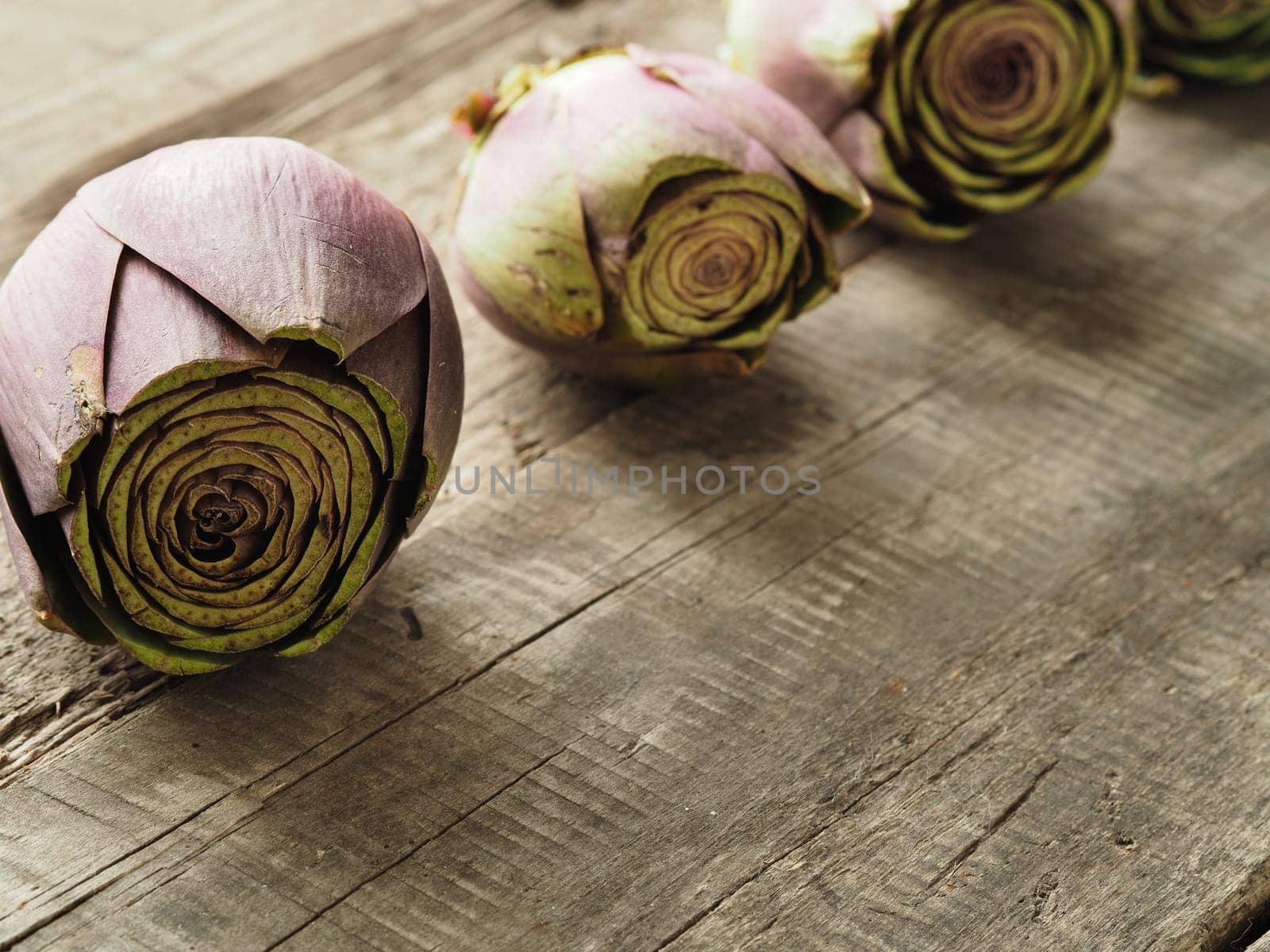 Healthy food concept with organic artichoke on a rustic wooden table, natural light with selective focus