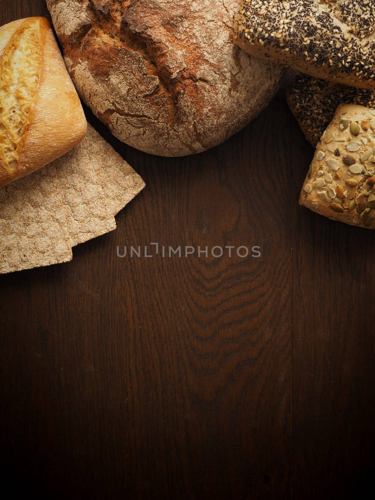 Tasty bread on a rustic wooden background with space for text, view from above