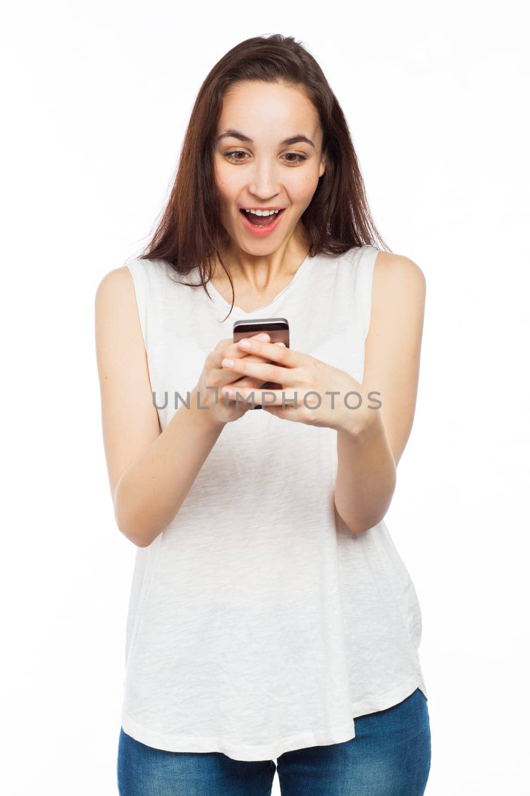 Young woman looking surprised using her phone, isolated on white
