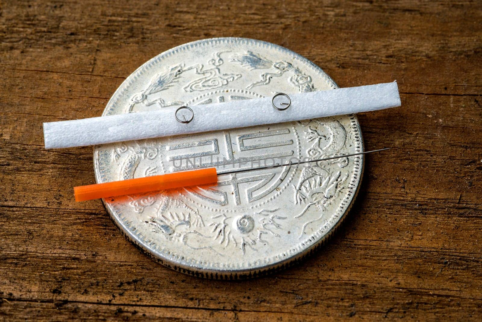 Acupuncture needle on antique Chinese coin