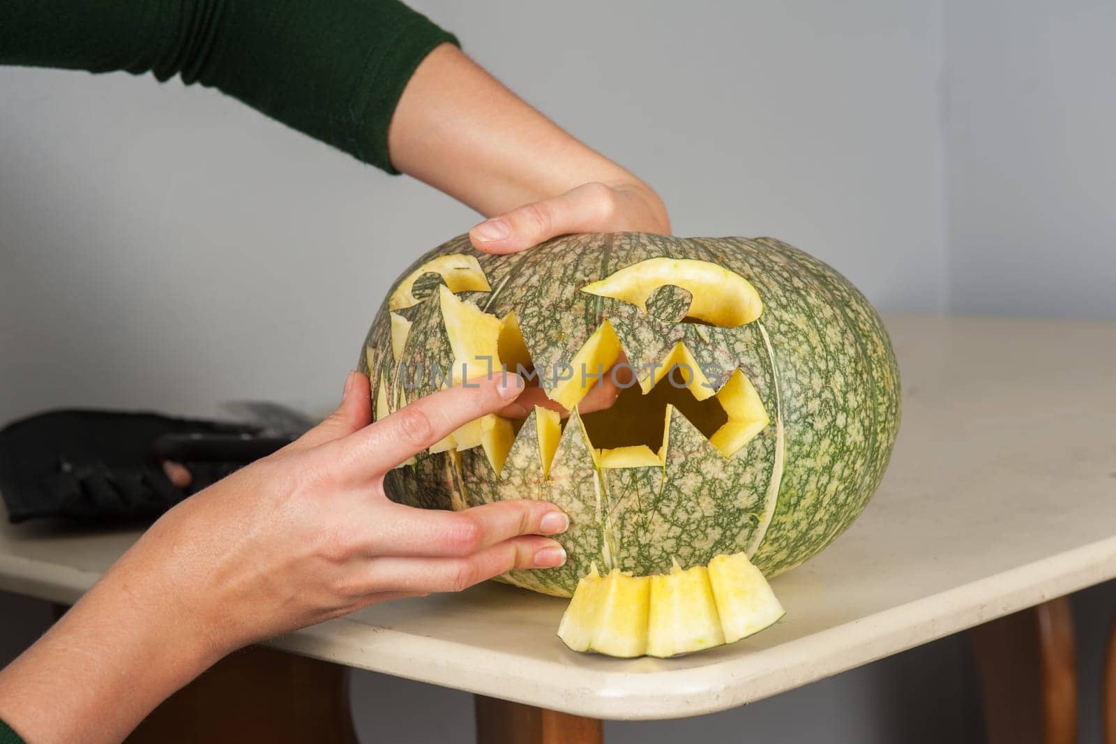 woman hands making pumpkin for halloween holidays.