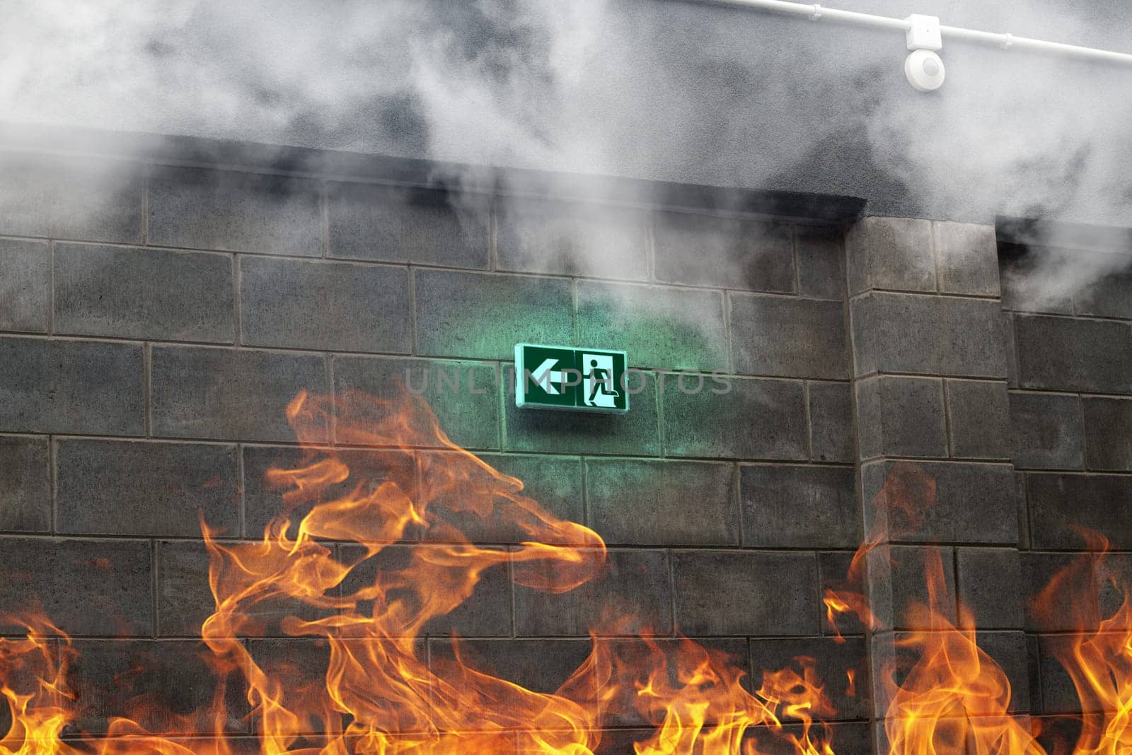 emergency fire exit on the stone wall with fire and smoke