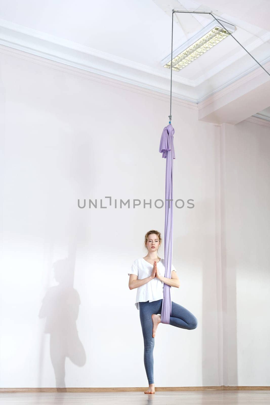 a woman is practicing yoga on a hose,aerial yoga