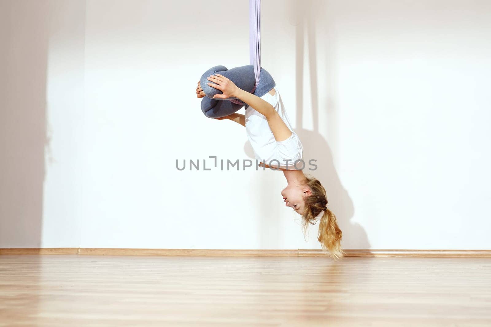 a woman is practicing yoga on a hose,aerial yoga meditation. woman meditating in the position of an inverted lotus flower