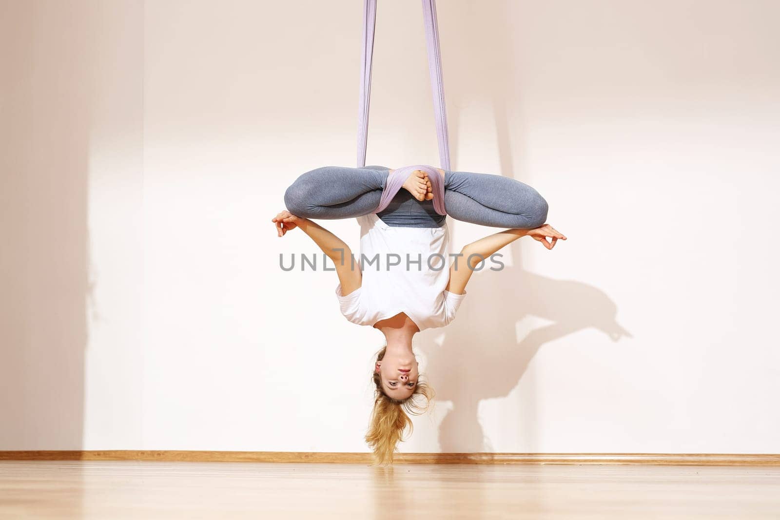 a woman is practicing yoga on a hose,aerial yoga meditation. woman meditating in the position of an inverted lotus flower