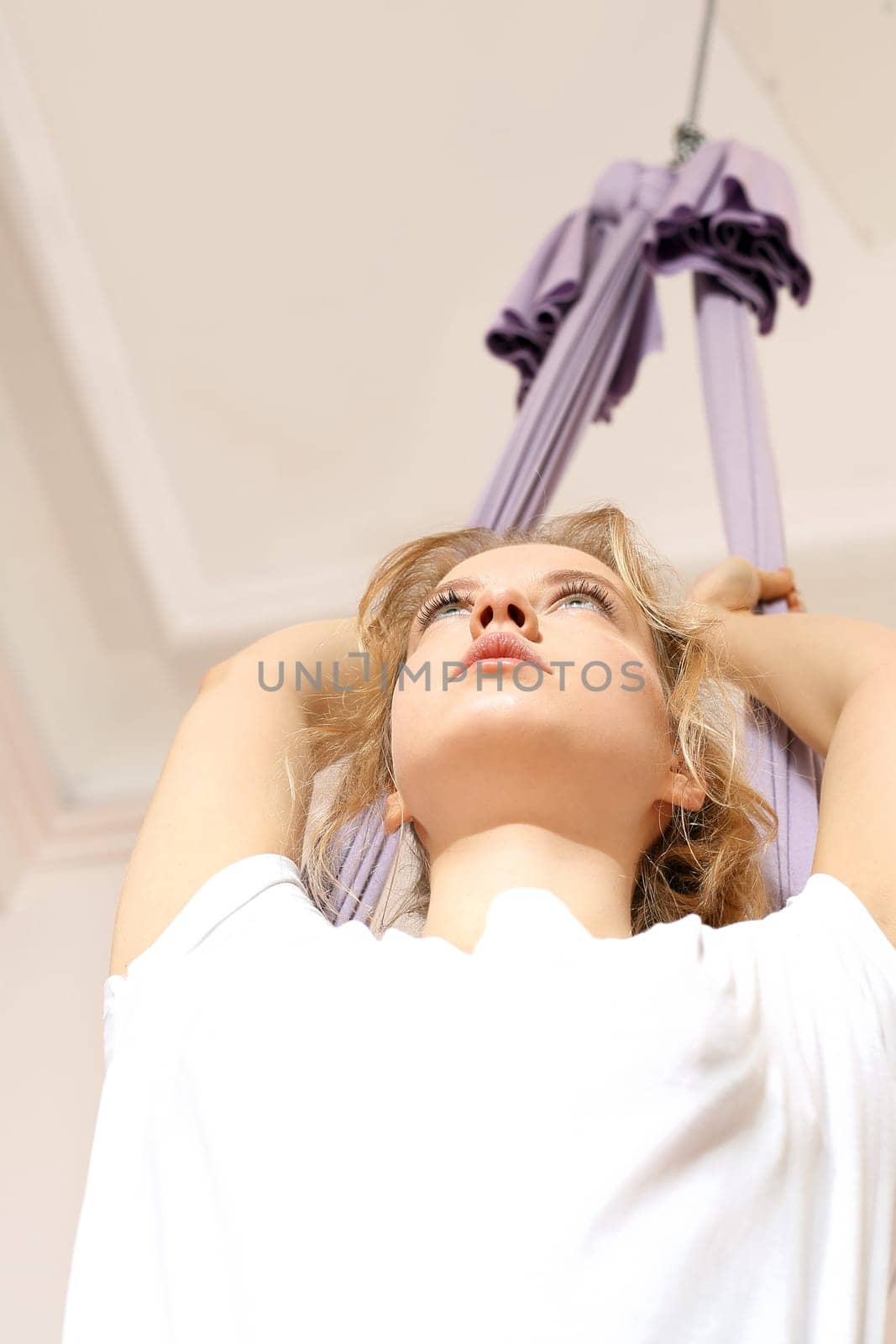 a woman is practicing yoga on a hose,aerial yoga