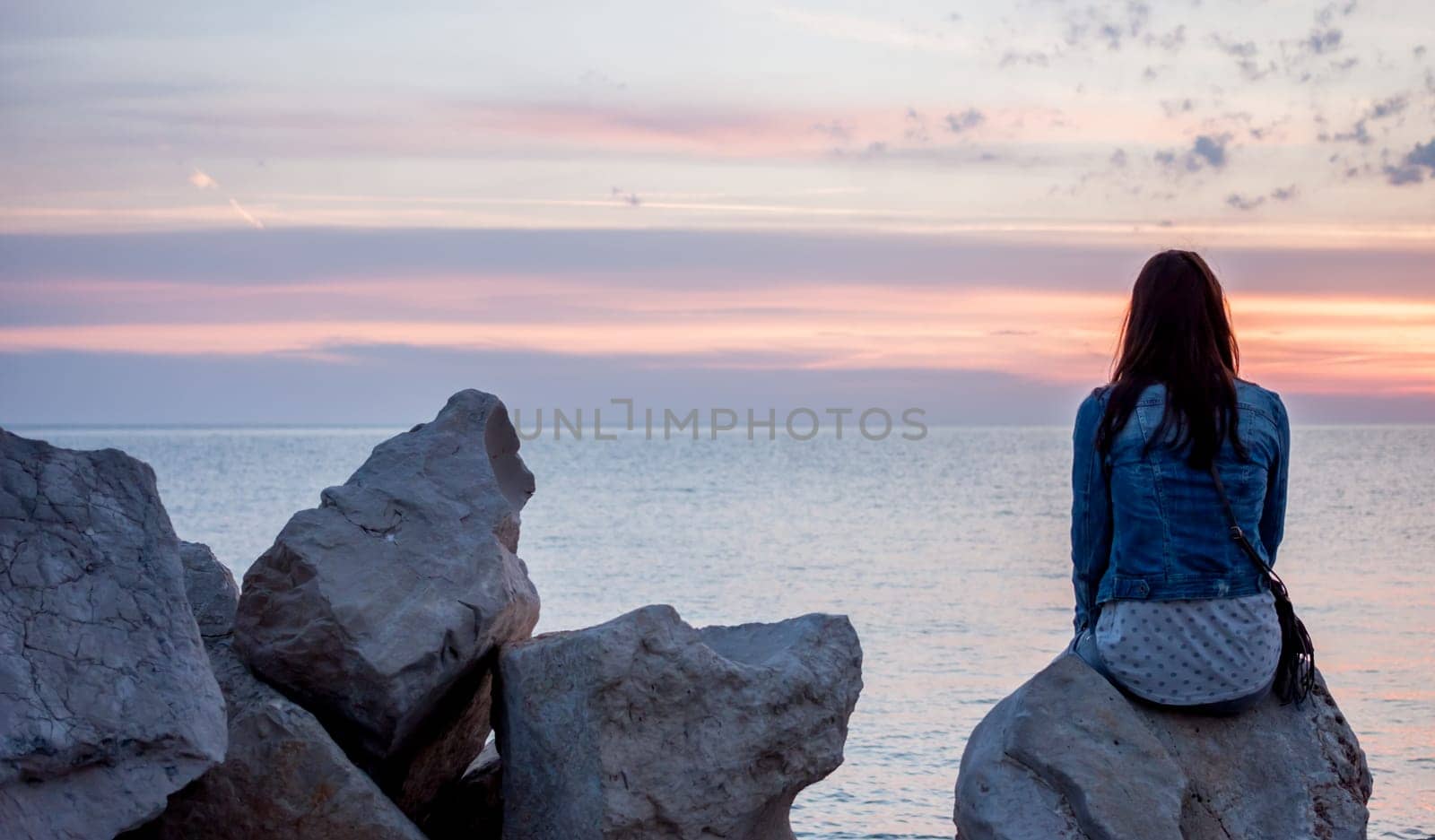colorful beautiful sunset over Adriatic sea woman looking at horizon