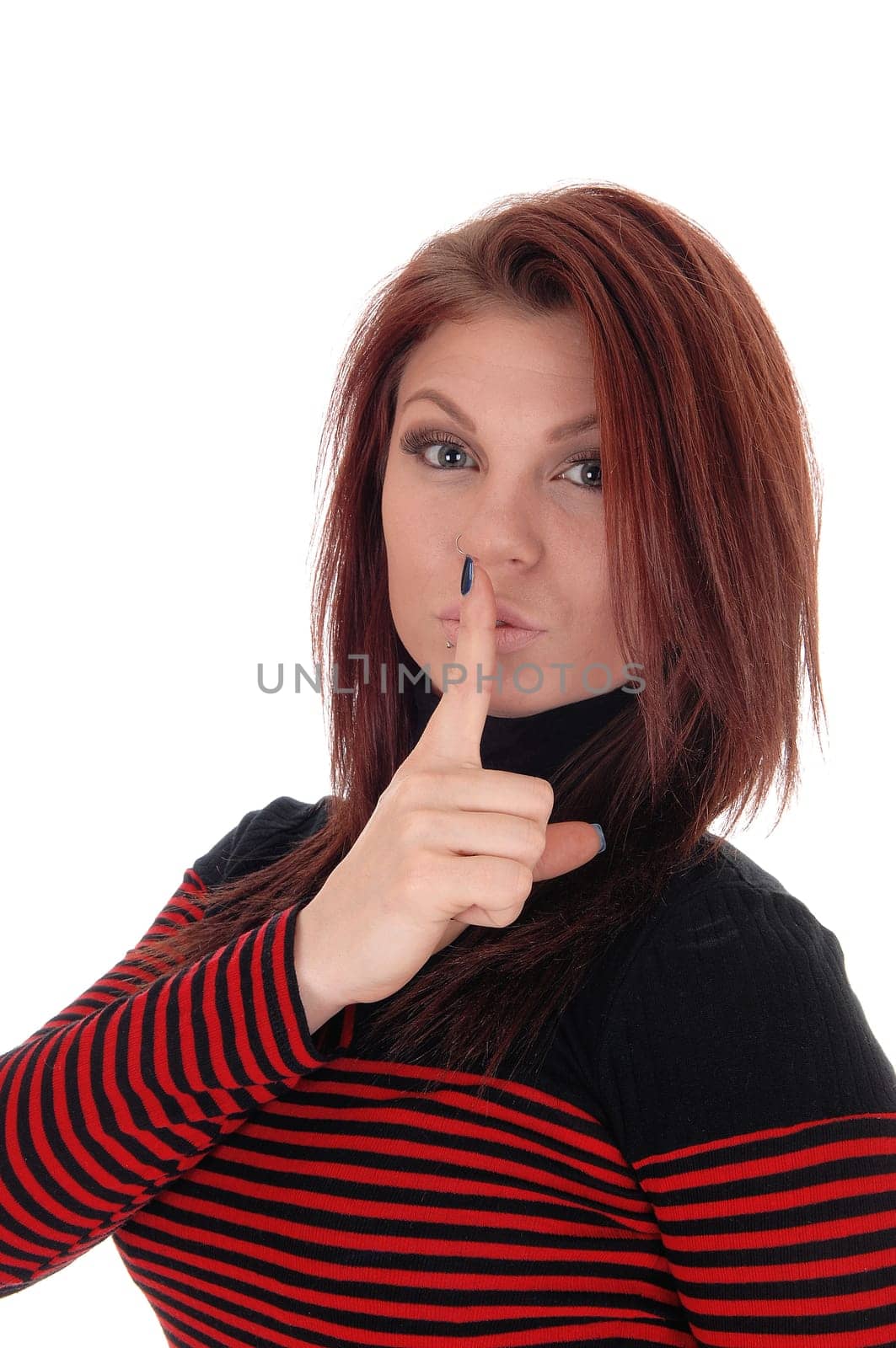 A pretty woman in a red and black striped dress holding her finger over.her mouth, isolated for white background..