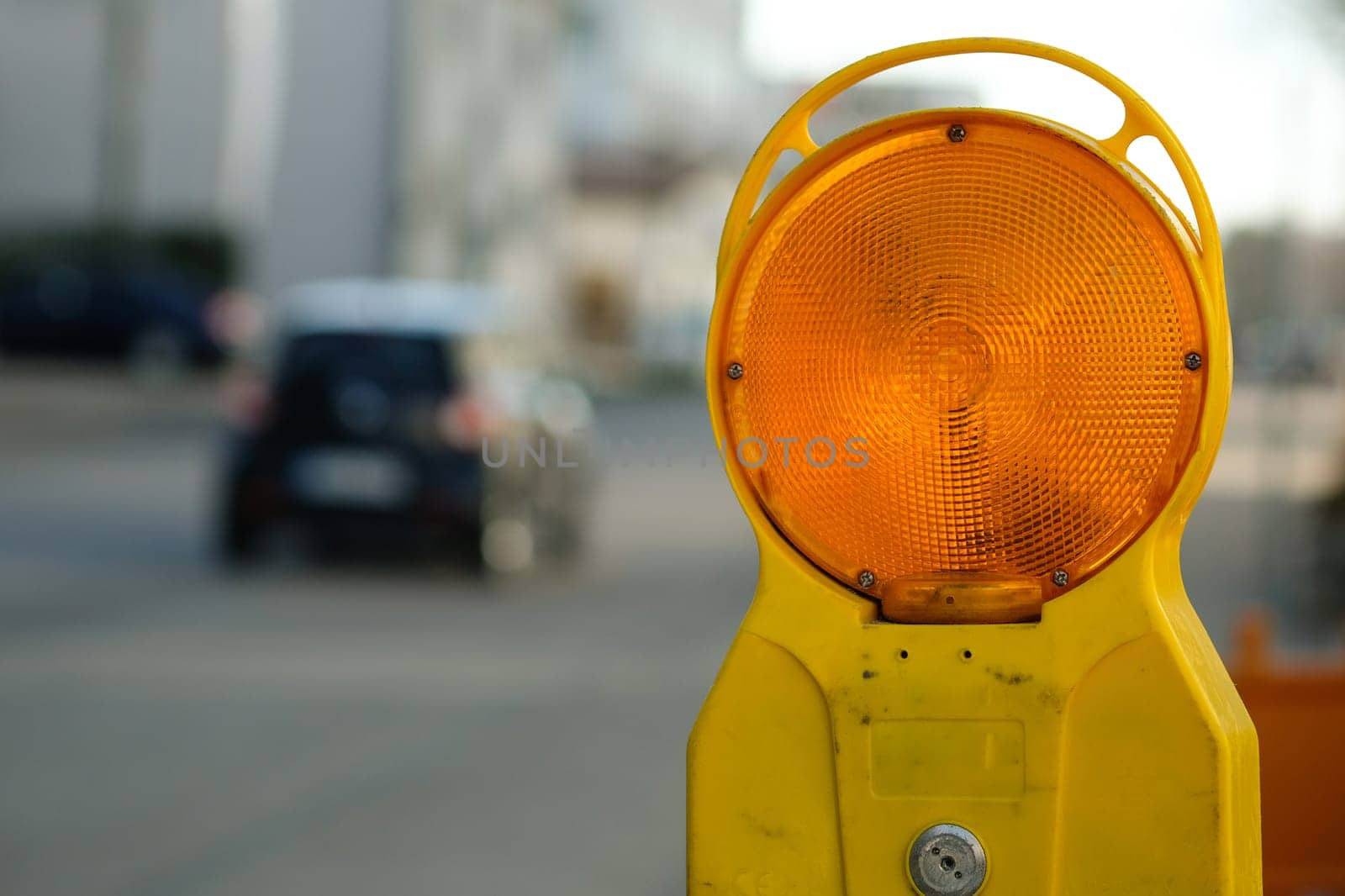 Warning light orange construction site and car blurred as a close-up