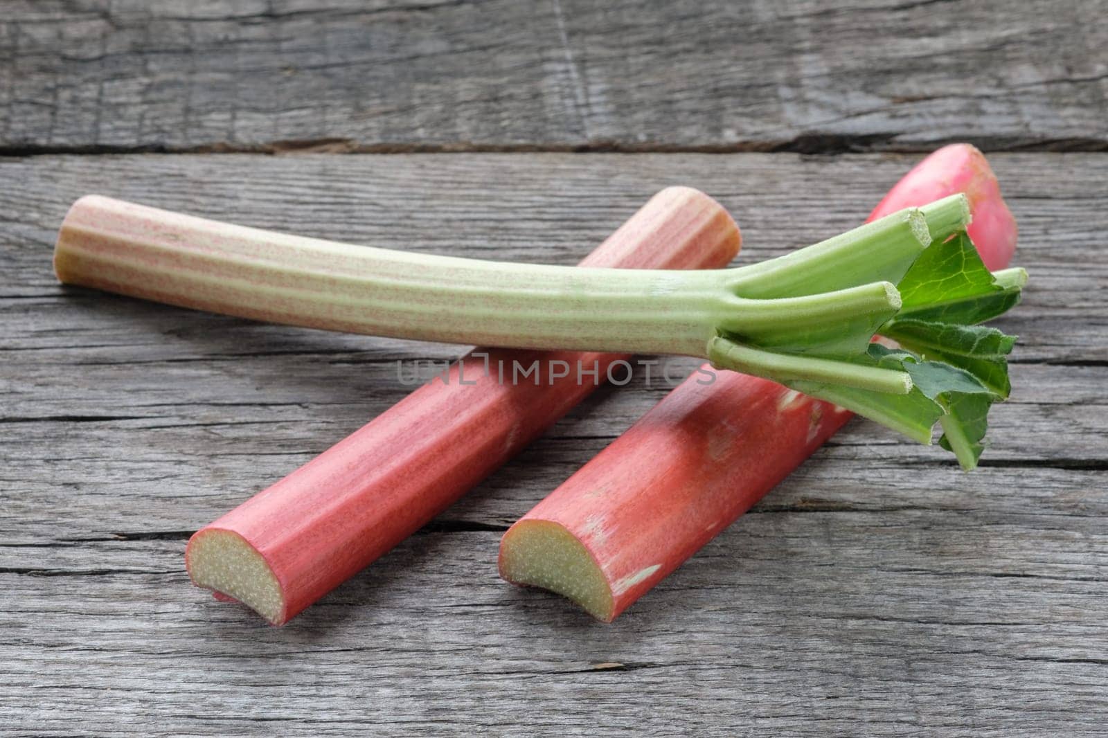 Raw rhubarb on wood in backlight
