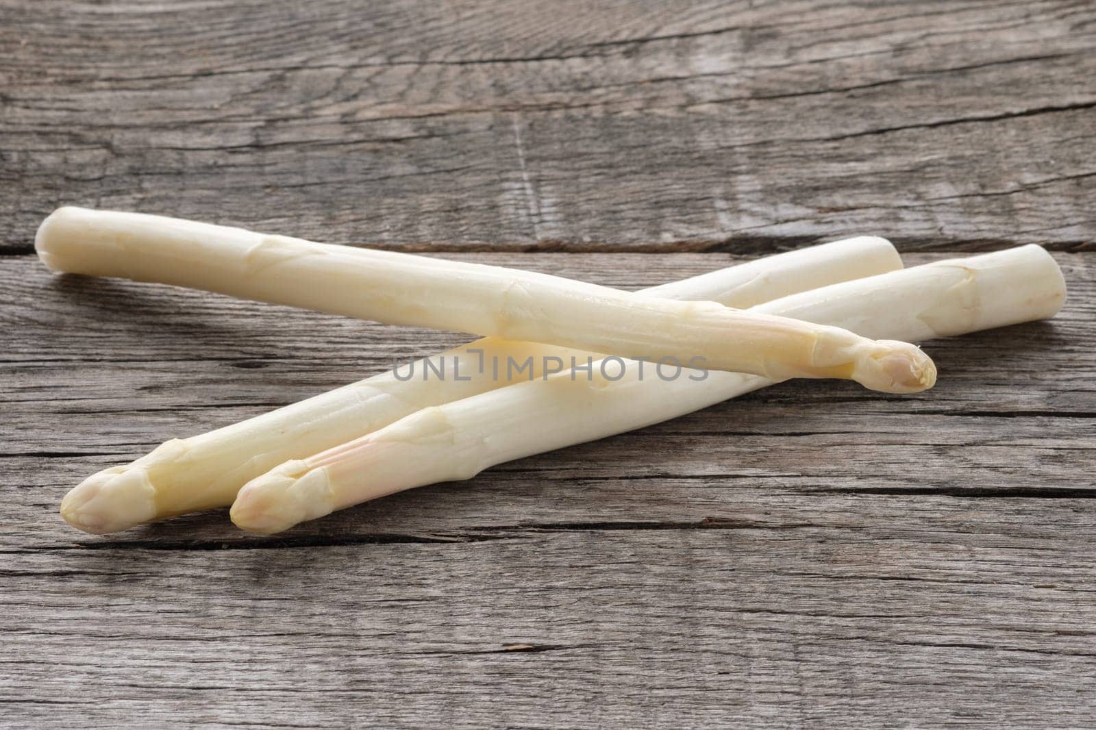White asparagus raw on rustic wood