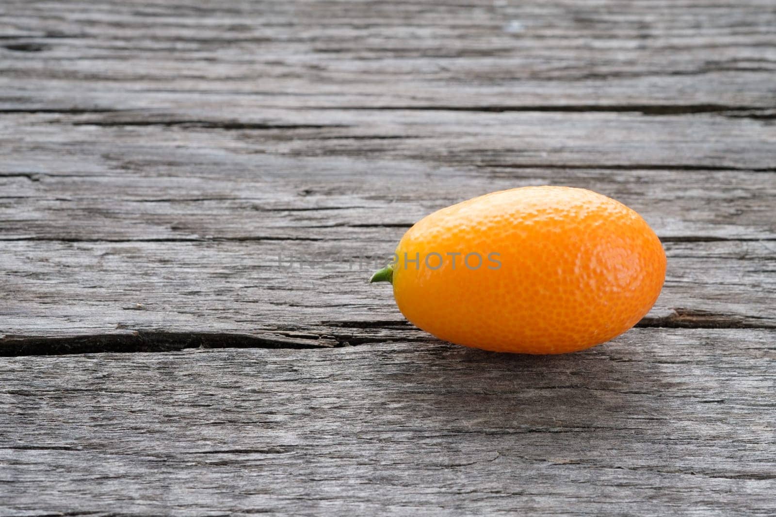 Orange citrus fruit kumquat on rustic wood