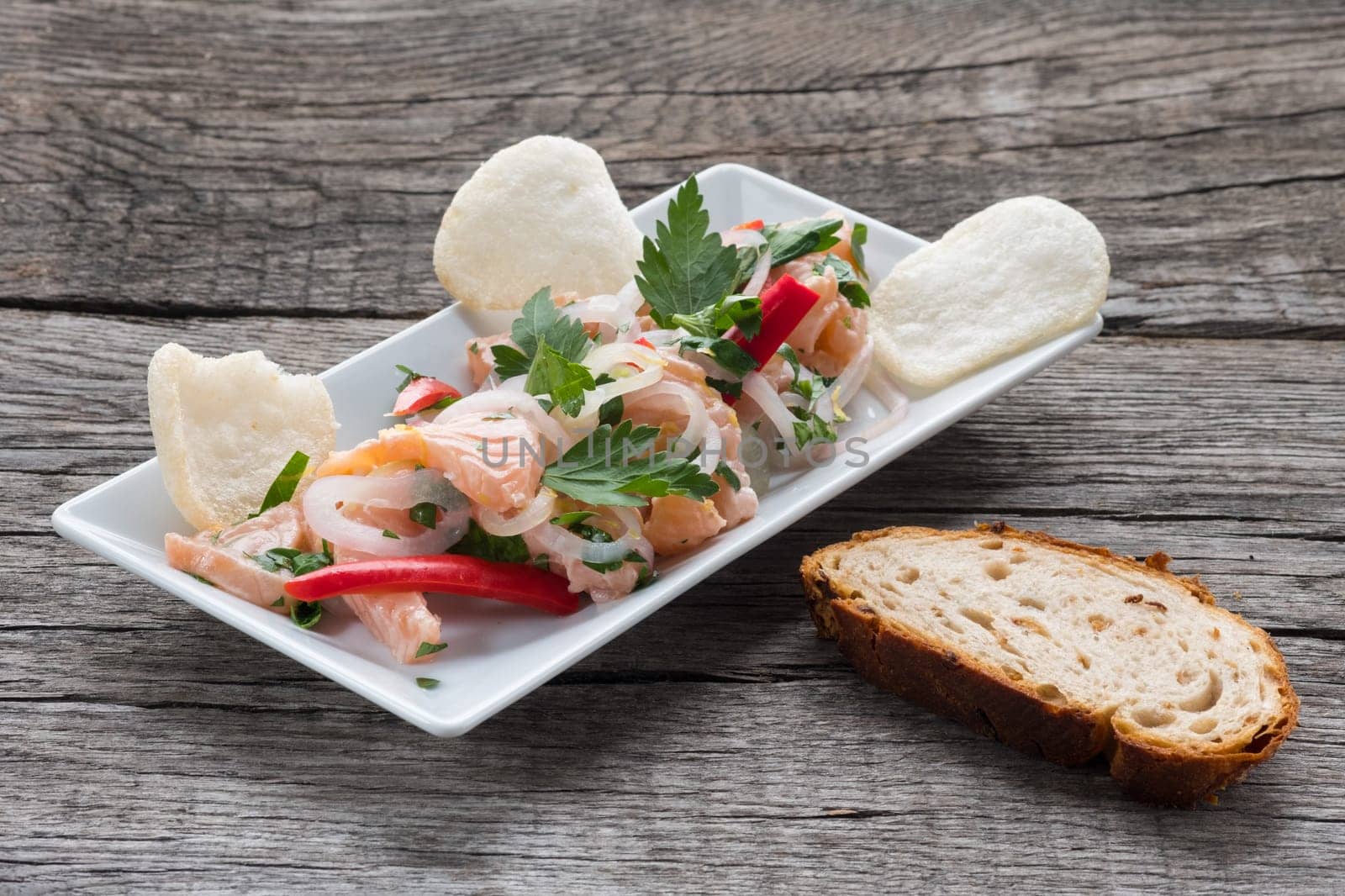 Chevice of salmon,onions,chili and parsley and slice of bread