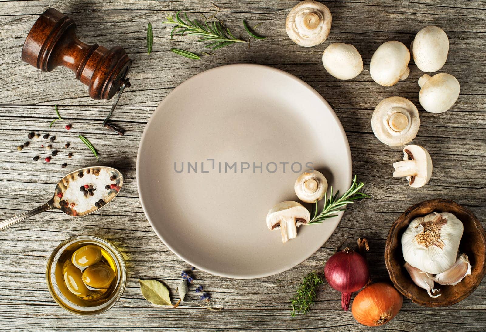 Mushrooms champignons with fresh ingredients on wooden background