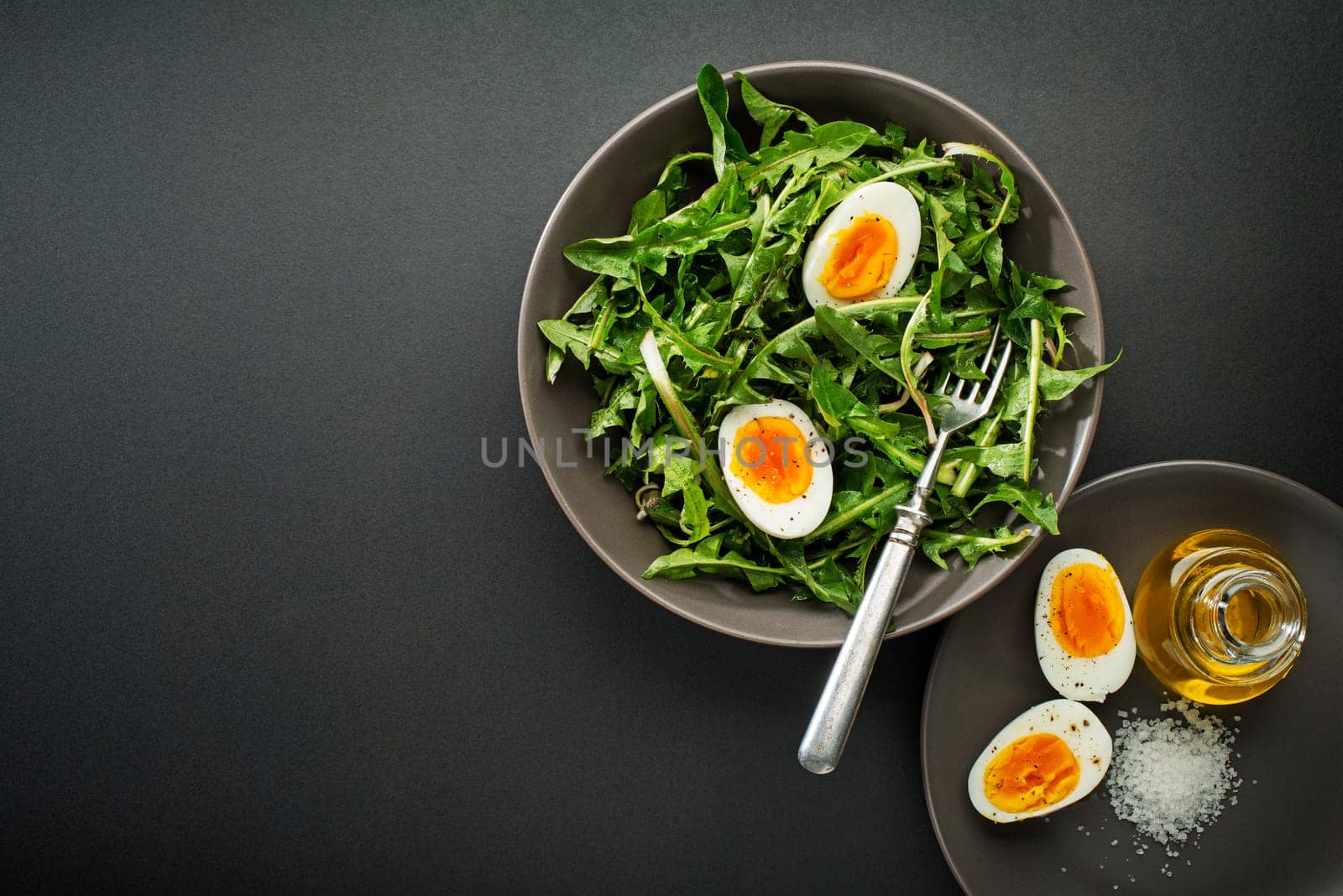 Fresh healthy dandelion salad with eggs overhead shoot