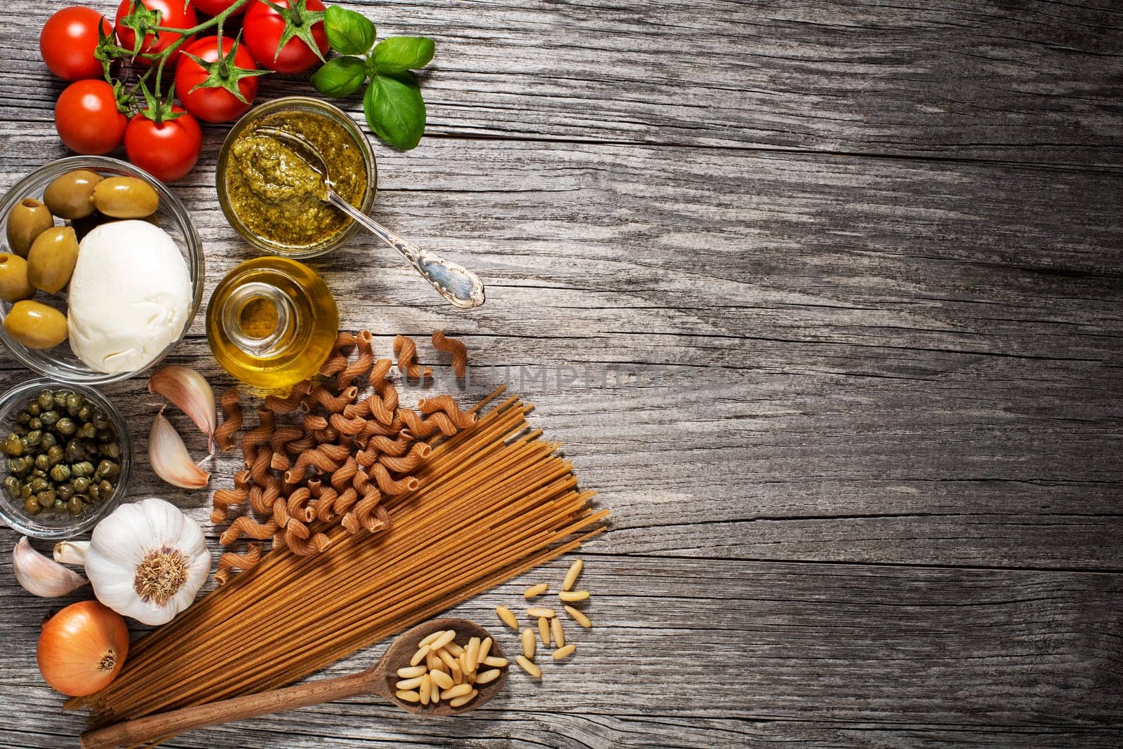 Healthy pasta with fresh ingredients on wooden background