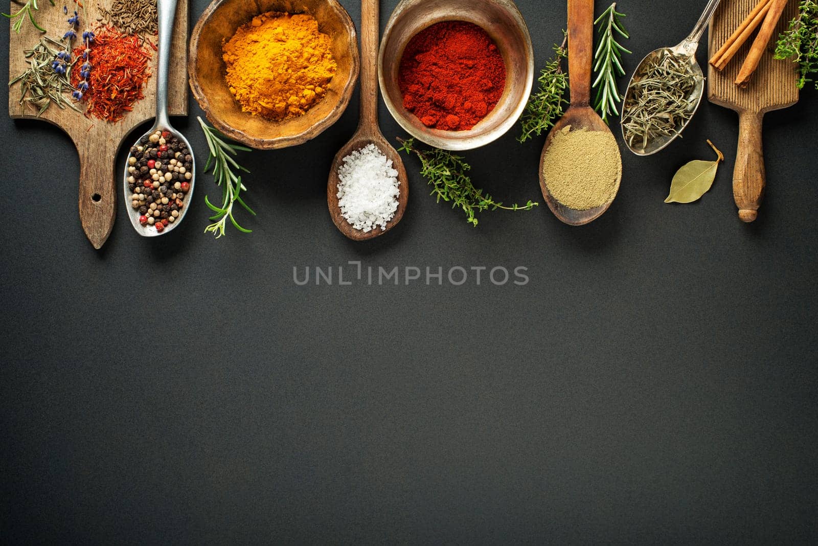 Fresh herbs and spices on a black background