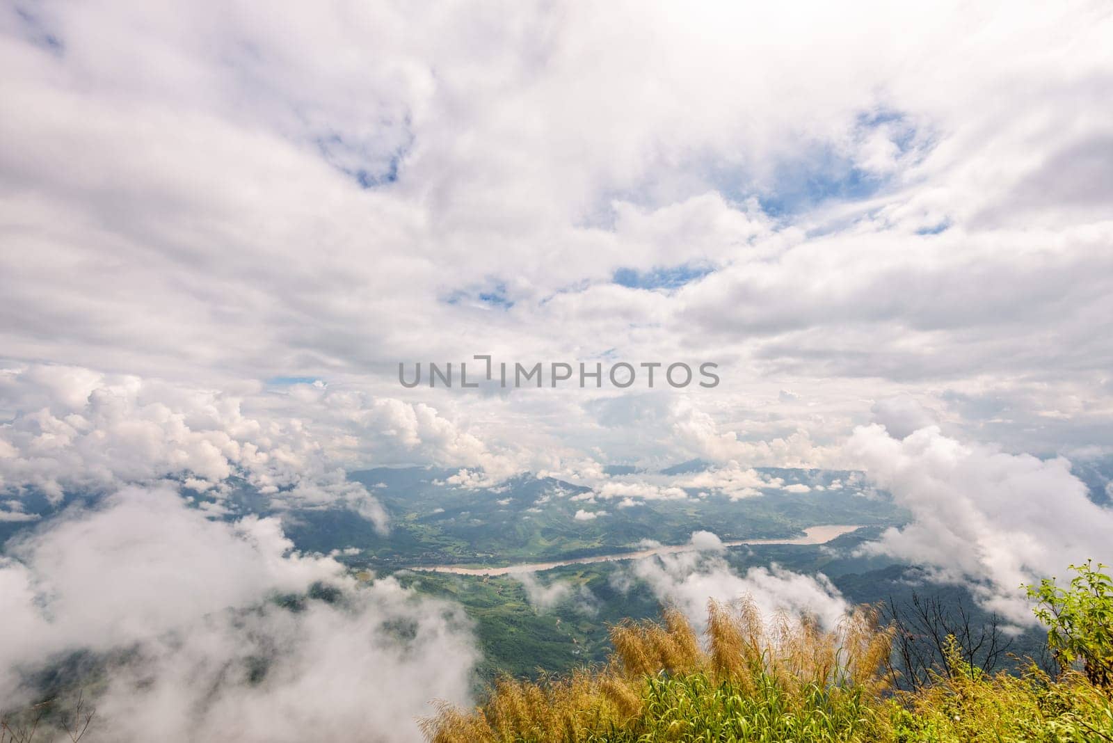 Beautiful natural landscape from high angle view of Mekong River forest and white clouds in the sky on the mountain at Doi Pha Tang view point, Chiang Rai Province, Thailand
