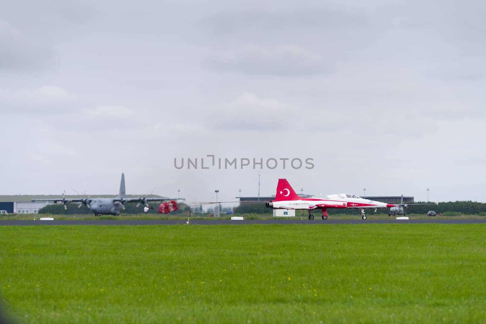 LEEUWARDEN, NETHERLANDS - JUNE 10, 2016: One of the NF-5 Canadair fighter planes of Turkish Star aerobatic demonstration team is landing with a parachute
