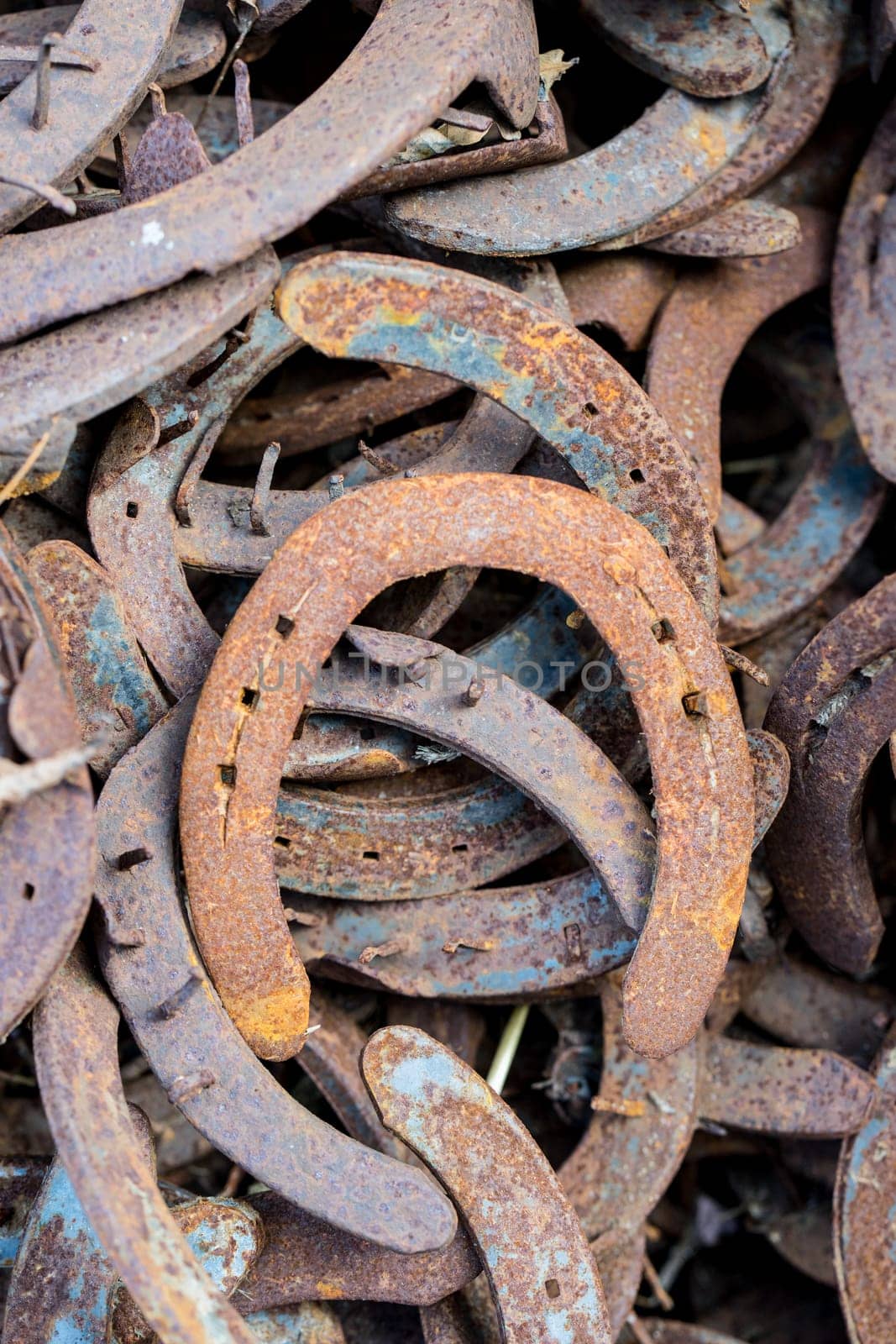 Heap of used and worn rusty Horseshoes outside blacksmith farriers shop or smithy