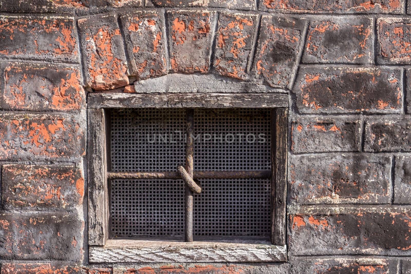 old window in the building with cross bars on the window to avoid unwelcome intrusion