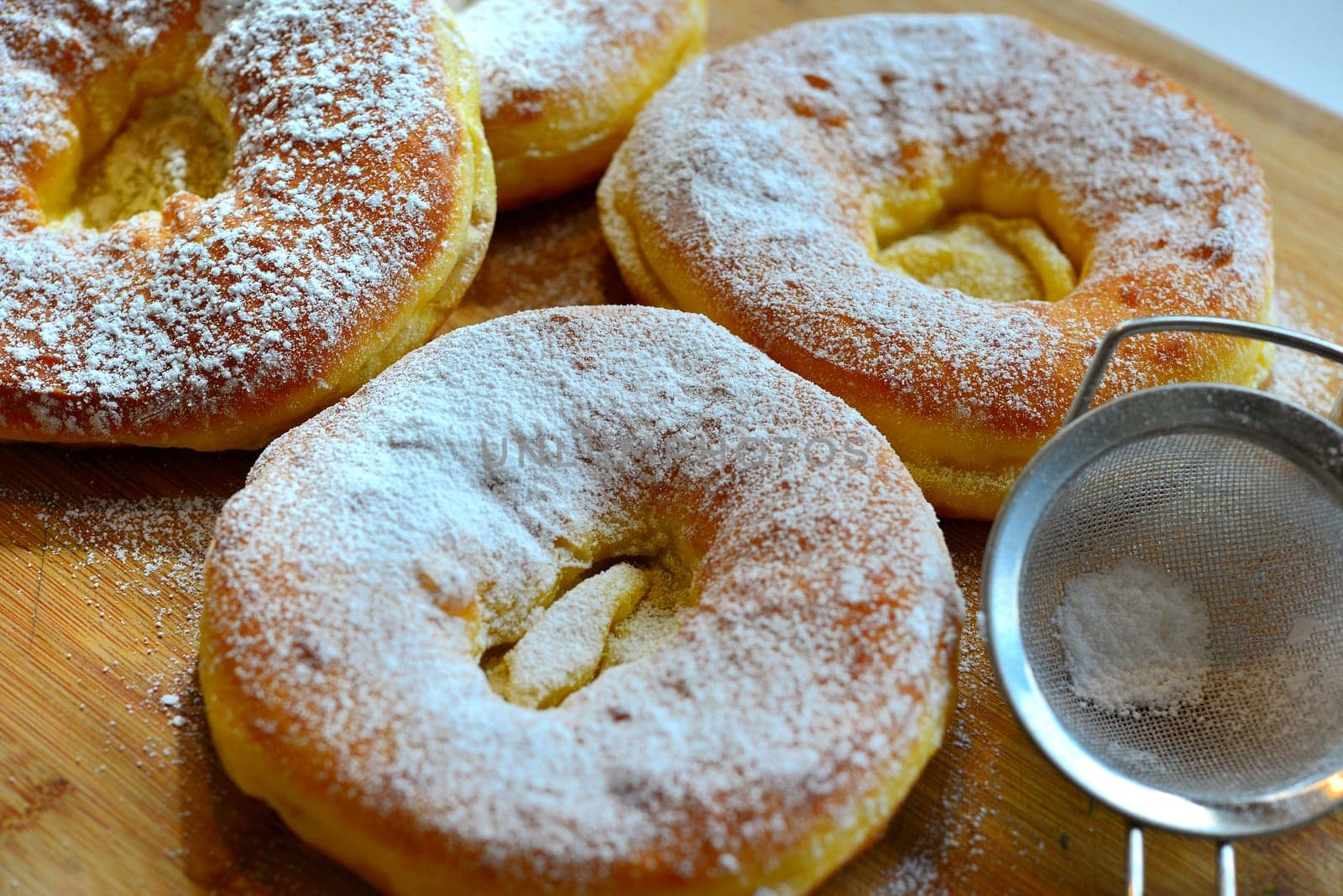 Photo freshly baked pulled out Küchle doughnuts with icing sugar