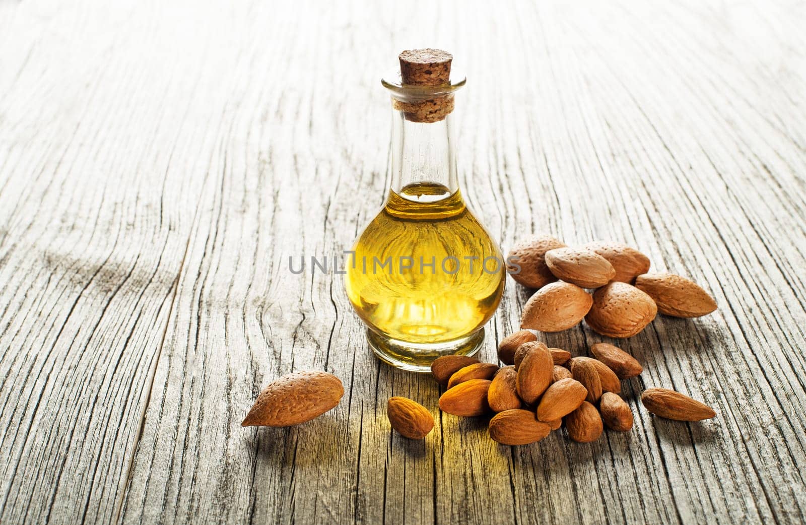 Almond oil in a glass bottle on a wooden background