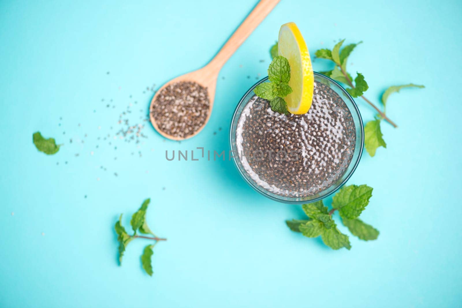 Selective focus of chia seeds drink with water in transparent glass with lemon balm.